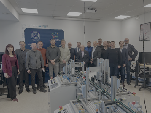 Grupa ludzi stojąca na tle ściany.